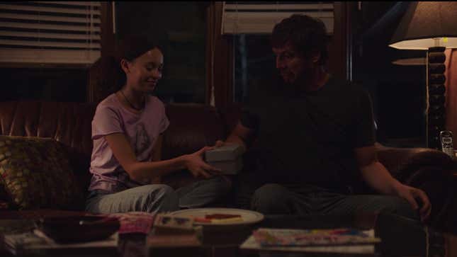 Sarah hands Joel a box containing a birthday present in a moment from HBO's The Last of Us.