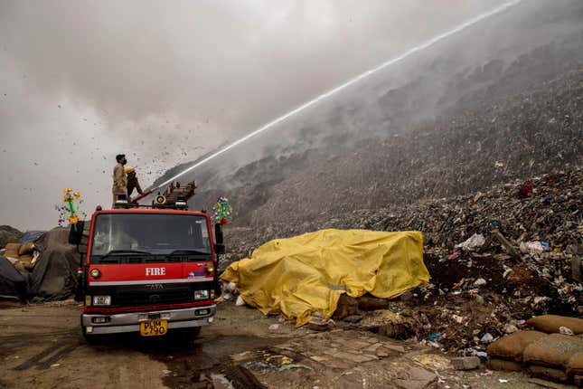 Firefighters try to douse the fire.