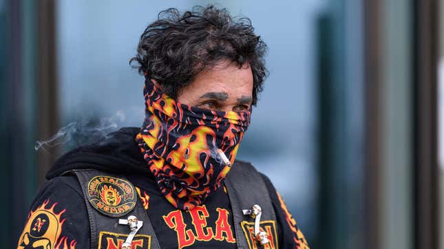 A man smokes a cigarette through his scarf on March 26, 2020 in Christchurch, New Zealand.