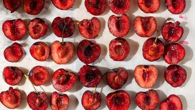 Cherries halved sitting on baking sheet for roasting