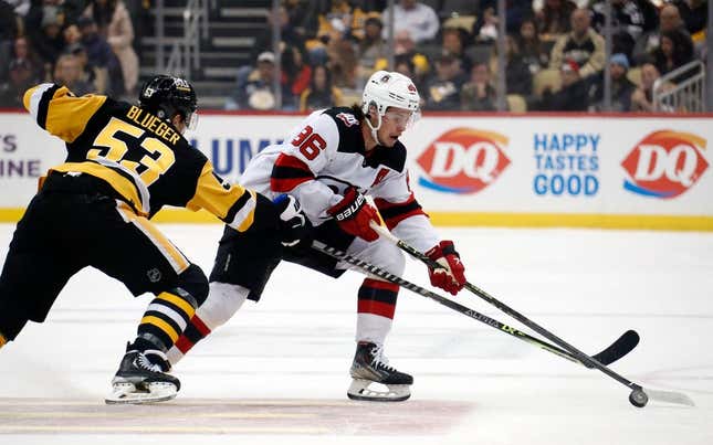 Feb 18, 2023; Pittsburgh, Pennsylvania, USA;  New Jersey Devils center Jack Hughes (86) moves the puck against Pittsburgh Penguins center Teddy Blueger (53) during the first period at PPG Paints Arena.