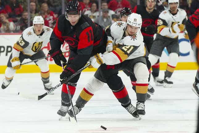 Mar 11, 2023; Raleigh, North Carolina, USA;  Carolina Hurricanes center Jordan Staal (11) and Vegas Golden Knights center Brett Howden (21) battle over the puck during the first period at PNC Arena.