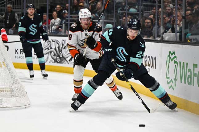 Mar 30, 2023; Seattle, Washington, USA; Seattle Kraken defenseman Jamie Oleksiak (24) protects the puck from Anaheim Ducks left wing Max Jones (49) during the first period at Climate Pledge Arena.