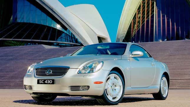 A photo of a silver Lexus SC430 in front of the Sydney Opera House. 
