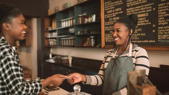 Customer smiling and handing card to cafe cashier