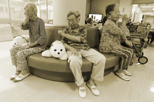 Ayako Shizo (C), 85, with Paro at the Suisyoen retirement home in Iwaki, Fukushima prefecture, Japan, July 28, 2011.