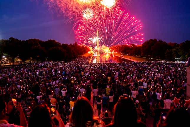 Spectators watch as fireworks erupt over the Washington Monument on July  4, 2022 in Washington, DC. Crowds lined the National Mall to watch the  capitals annual fireworks show celebrating Independence Day.