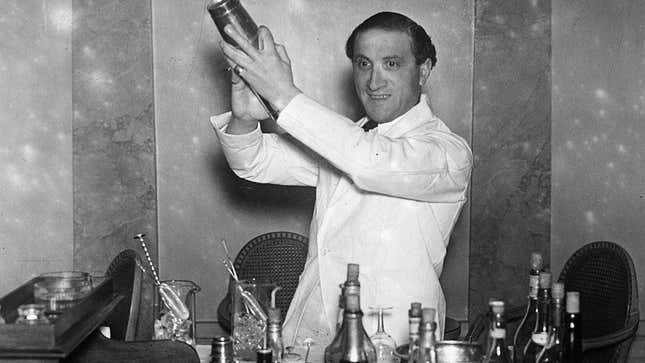 Black-and-white photo of barkeep in suit shaking cocktail in shaker