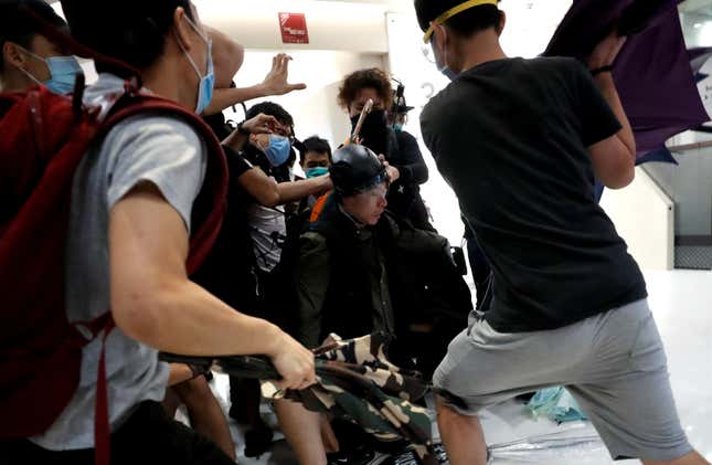 Pro-democracy activists hit a plainclothes police officer in a Hong Kong mall, July 14, 2019.