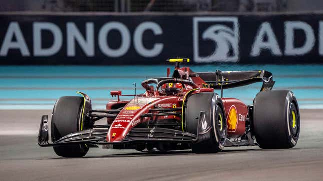 A photo of a red Ferrari f1 car racing in Abu Dhabi.