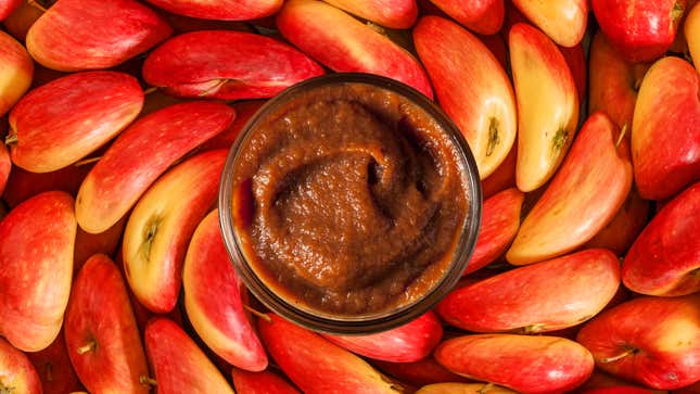 Overhead view of jar of Easy Apple Butter with apples in background