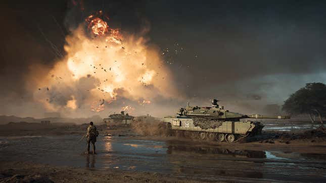 A solider in Battlefield 2042 watches a giant explosion in the background as tanks roll past.