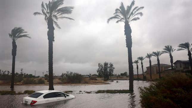 A car is partially submerged in floodwaters as Tropical Storm Hilary moves through the area on August 20, 2023, in Cathedral City, California. 