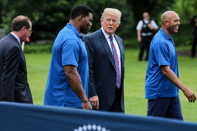 Former President Donald Trump, center, Herschel Walker, Mariano Rivera, far right, and Human Services Secretary Alex Azar, walk as they watch young participants during the White House Sports and Fitness Day on the South Lawn on May 30, 2018 in Washington, DC. 