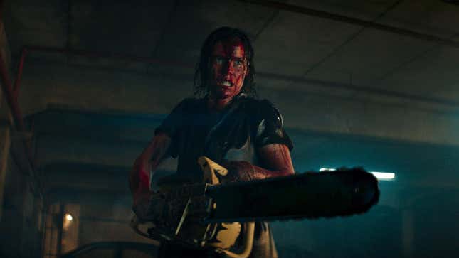 A blood-drenched woman holds a chainsaw in Evil Dead Rise