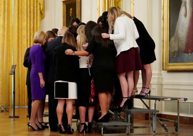 U.S. President Donald Trump prays with the Oklahoma Women’s Softball women team as he greets members of Championship NCAA teams at the White House on Nov. 17, 2017.