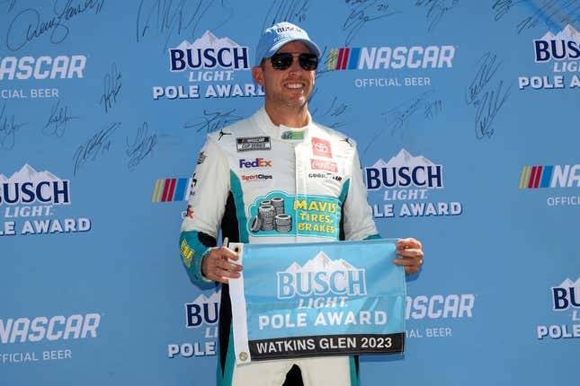 Aug 19, 2023; Watkins Glen, New York, USA; NASCAR Cup Series driver Denny Hamlin stands with the Busch Light Pole Award after winning the pole for the Go Bowling at The Glen at Watkins Glen International.