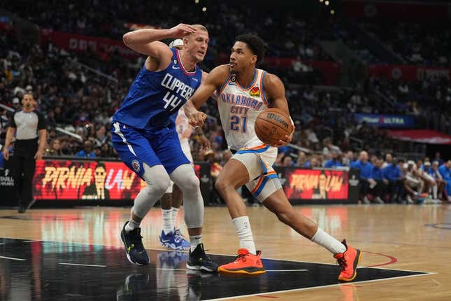 Mar 21, 2023; Los Angeles, California, USA; Oklahoma City Thunder guard Aaron Wiggins (21) dribbles the ball against LA Clippers center Mason Plumlee (44) in the second half at Crypto.com Arena.
