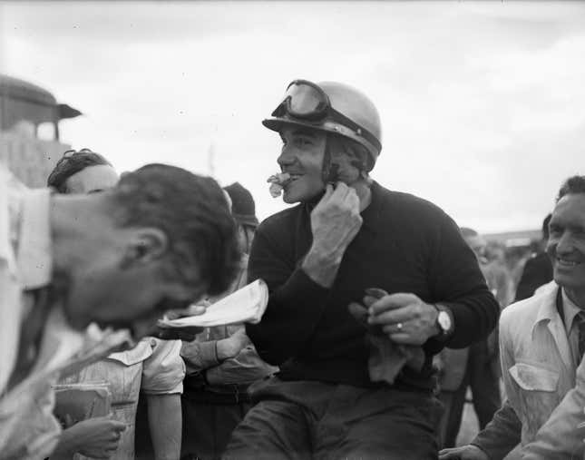 talian racing driver Piero Taruffiunfastens his helmet after winning the Libre trophy race at 1952 Silverstone.