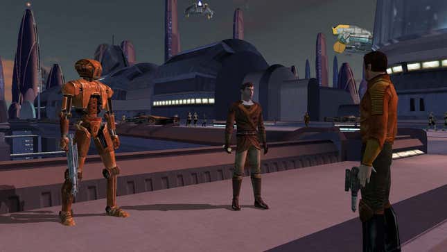 A screenshot from KotOR showing two humans standing near a golden-red colored droid. 