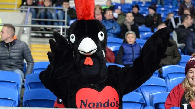 Nando's chicken mascot sitting in stands at sporting event