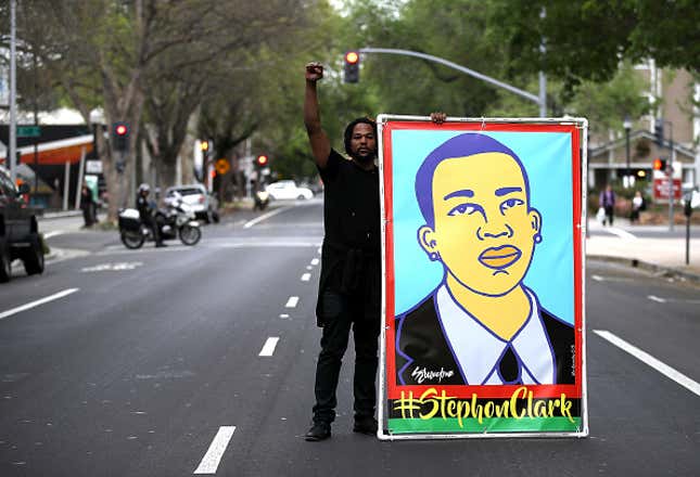 A Black Lives Matter protester holds an illustration of Stephon Clark during a march and demonstration through the streets of Sacramento on April 4, 2018 in Sacramento, California. Over 100 Black Lives Matter protesters rallied during a day of action outside of the Sacramento district attorney office demanding justice for Stephon Clark, an unarmed black man who was shot and killed by Sacramento police on March 18. 