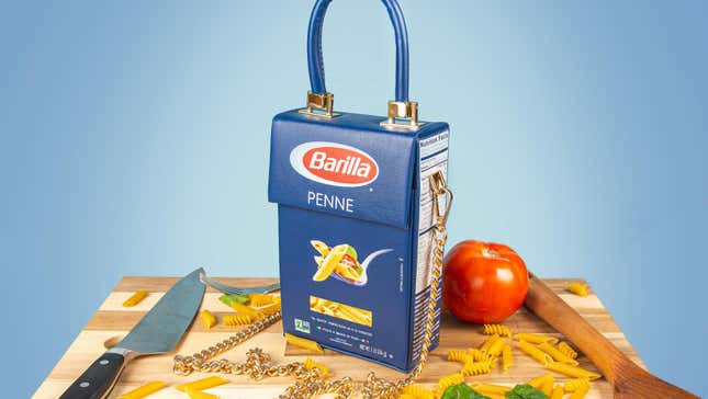 Barilla penne pasta bag on cutting board surrounded by noodles