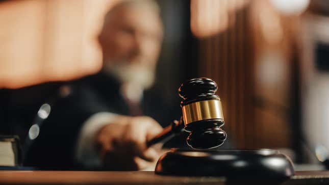 close-up of a gavel with judge blurry in background