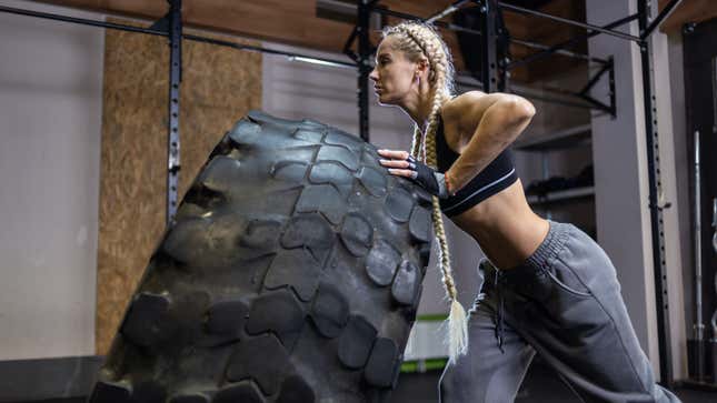 woman flipping a tire in the gym