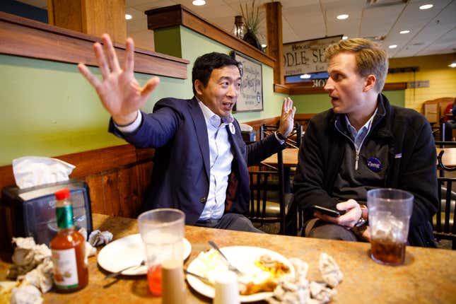 Democratic presidential candidate Andrew Yang talks with campaign manager Zach Graumann as they eat dinner before an event on April 27, 2019, in Boone, Iowa.