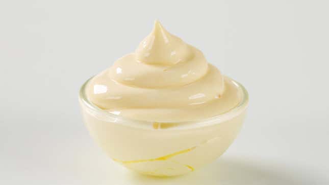 Mayonnaise in a glass bowl on white background