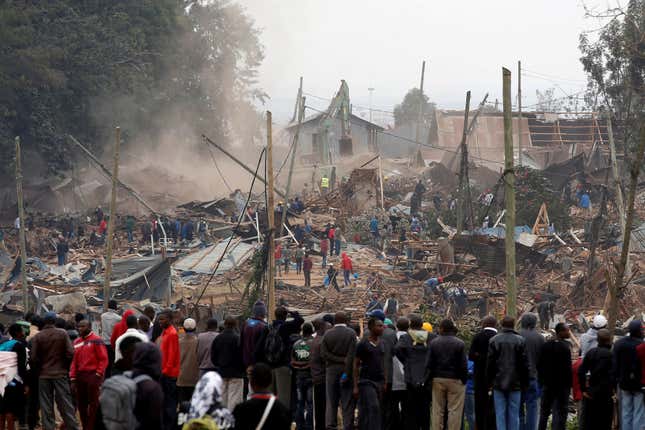 Onlookers watch as bulldozers demolish houses to make way for a new road in the Kibera slum in Nairobi, Kenya, July 23, 2018.