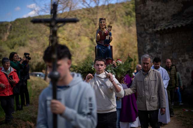 Local residents take part in a procession carrying a statue of the Our Lady of the Torrents, a virgin historically associated with drought, in l’Espunyola, north of Barcelona, Spain, Sunday, March 26, 2023.