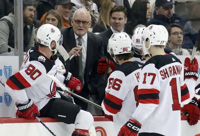 Feb 18, 2023; Pittsburgh, Pennsylvania, USA;  New Jersey Devils head coach Lindy Ruff (second from left) talks to his team during a time-out against the Pittsburgh Penguins in the third period at PPG Paints Arena. The Devils won 5-2.