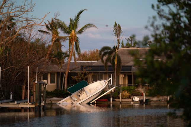 A boat is washed up onto the pier of a home in Sanibel Island on Saturday, October 1. 