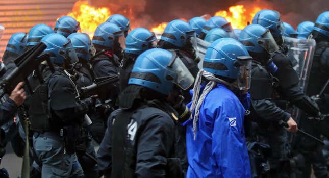 Riot police advance during the clashes in Milan.