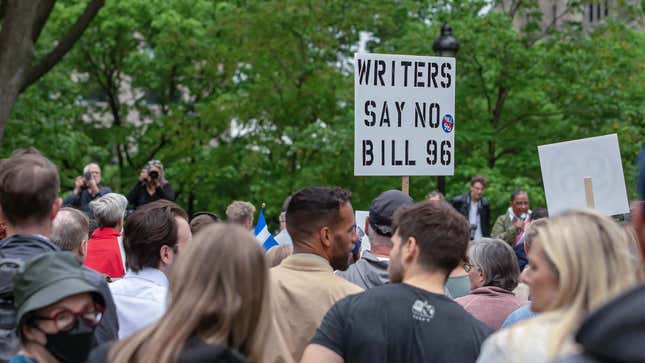 A group of protestors holds a sign while gathering in Montreal to oppose the controversial Bill 96. 