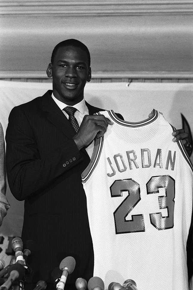 Former North Carolina star, College Player of the Year and star of the US Olympic gold medal-winning basketball team, Michael Jordan holds up his Chicago Bulls jersey 9/12 at a news conference. Bulls General Manager Rod Thorn announced they have signed Jordan, their first-round draft pick, to a multi-million dollar contract which is expected to make him the third-highest paid in NBA history.