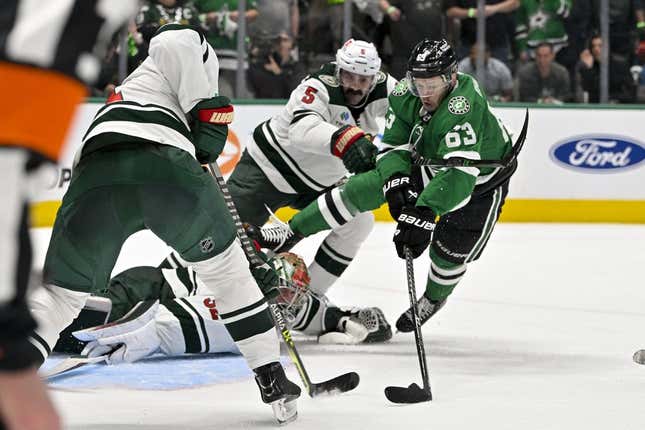 Apr 17, 2023; Dallas, Texas, USA; Minnesota Wild defenseman Jake Middleton (5) checks Dallas Stars right wing Evgenii Dadonov (63) as he attempts to poke the puck past goaltender Filip Gustavsson (32) during the first overtime period in game one of the first round of the 2023 Stanley Cup Playoffs at the American Airlines Center.