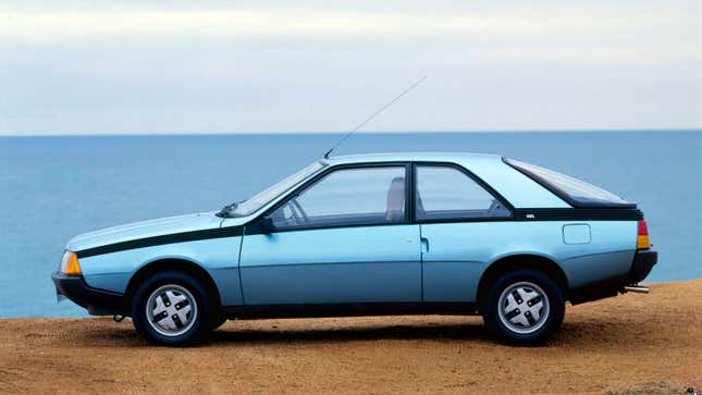 A blue Renault Fuego car parked at a beach. 