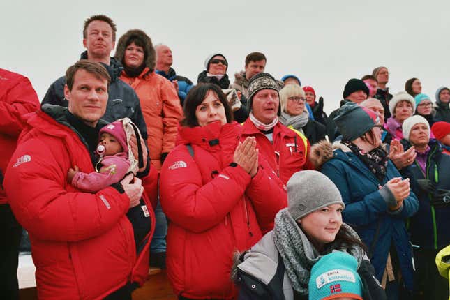 Spectators cheer on the mushers at the finish line.