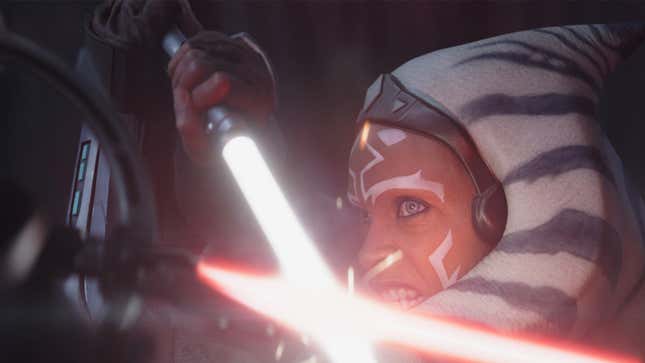 Ahsoka blocks a red lightsaber with her white one, a snarl on her face.