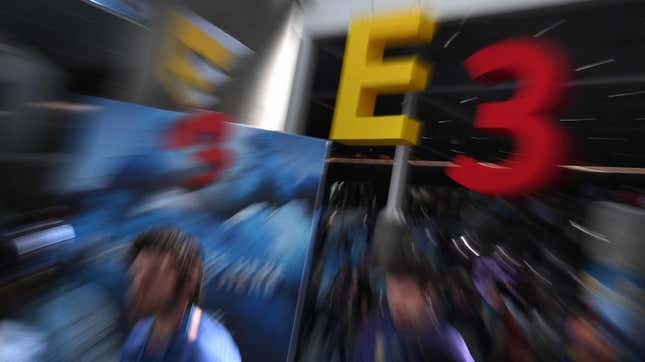 A blurry photograph of E3 2017 shows a giant logo behind convention goers. 