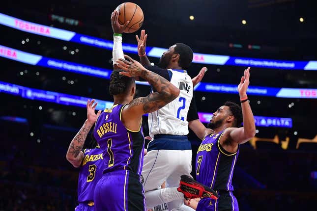 Mar 17, 2023; Los Angeles, California, USA; Dallas Mavericks guard Kyrie Irving (2) shoots against Los Angeles Lakers forward Anthony Davis (3) guard D&#39;Angelo Russell (1) and forward Troy Brown Jr. (7) during the first half at Crypto.com Arena.