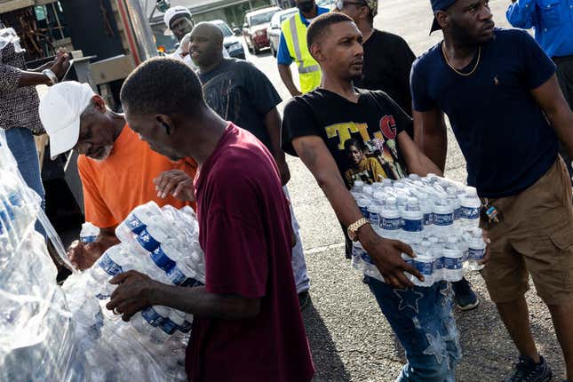 Cases of bottled water were handed out at a Mississippi Rapid Response Coalition distribution site on August 31, 2022, in Jackson, Mississippi. Jackson is experiencing a third day without reliable water service after river flooding caused the main treatment facility to fail. Late Tuesday night, President Joe Biden declared an emergency amid the crisis. (