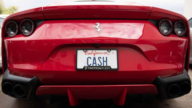 The rear view of a red Ford Mustang with the California license plate reading CASH