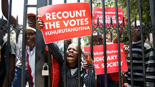 Supporters of Kenya's President Uhuru Kenyatta carry placards as they demonstrate outside the Supreme Court in protest of the nullification of Kenyattaís victory by the Supreme Court Judges in Nairobi, Kenya, September 19, 2017.