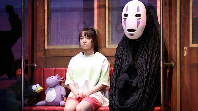 Chihiro, No-Face, and a bird and mouse sit in silence in a train car.