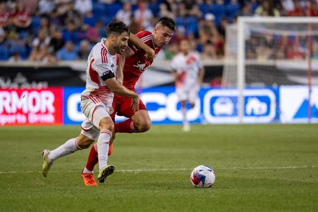 Jul 22, 2023; Harrison, NJ, USA; New England Revolution midfielder Carles Gil (10) fights for the ball against New York Red Bulls defender Sean Nealis (15) during the first half at Red Bull Arena.