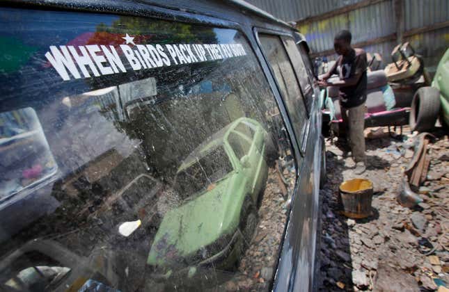 A painter strips paintwork and decals from a matatu or minibus-taxi at the Moha Graphics bodyshop in the Eastleigh area of Nairobi, Kenya.